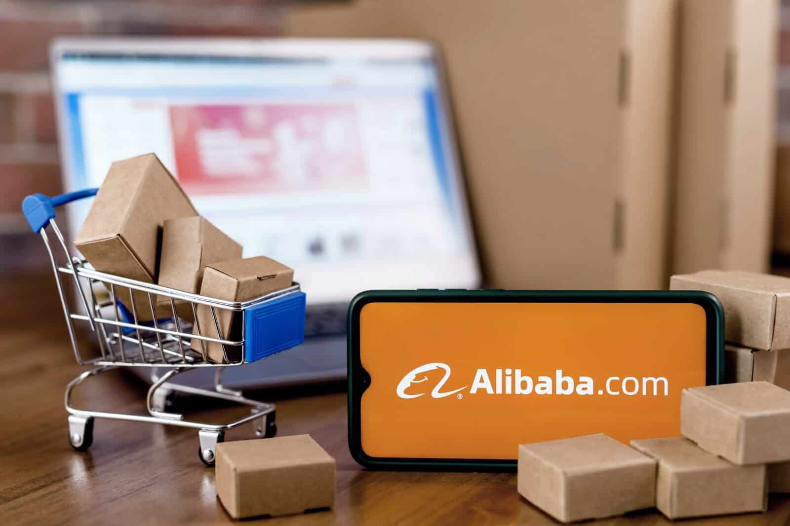handy mit alibaba schriftzug neben einem einkaufswagen mit top pick liste paketen tech konzernen