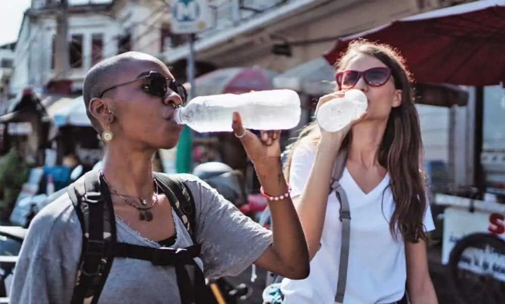 Frauen trinken aus Wasserflaschen