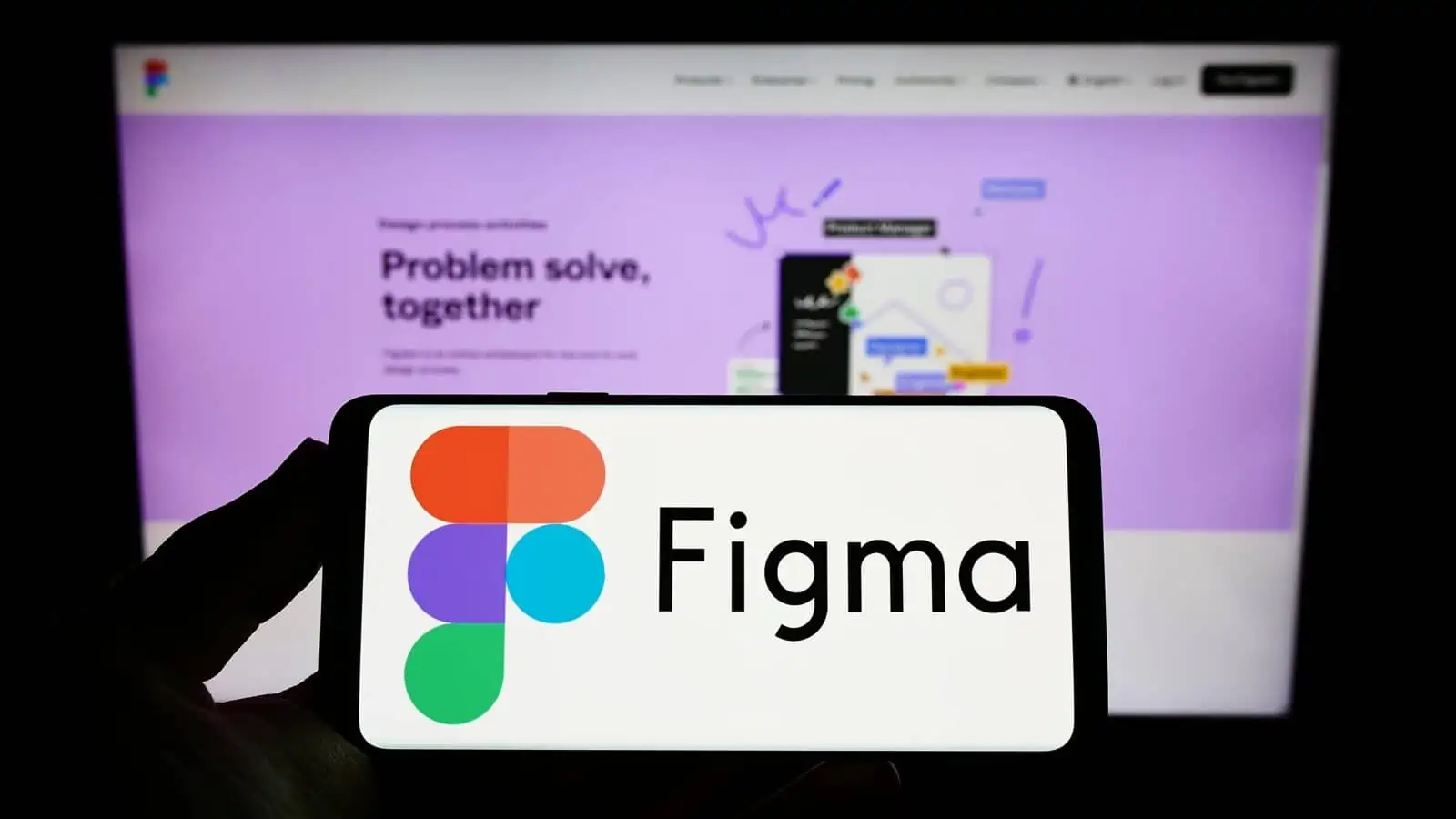 Figma logo auf einem handy vor einem laptop bildschirm