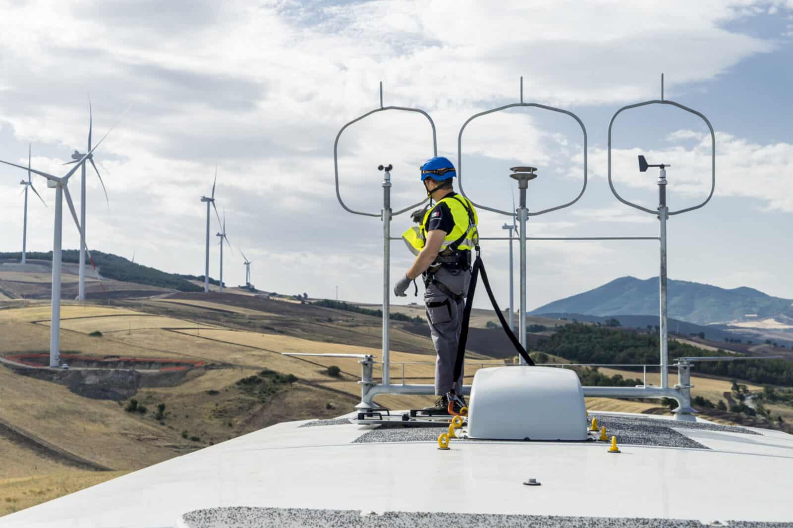 arbeiter steht oben auf einer windkraftanlage, ausblick deutschland, onshore anlagen im megawatt bereich